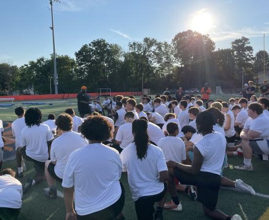 Players kneel on the field for A Call to Men Football Camp